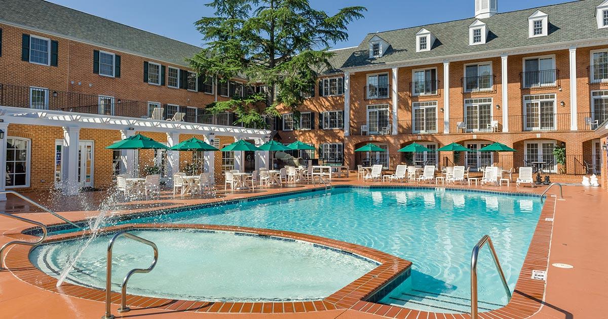 Piscina al aire libre rodeada de edificios de ladrillo en Westgate Historic Williamsburg Resort.