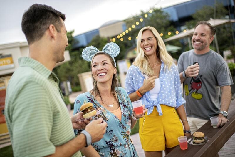Amigos disfrutando de comida y bebidas al aire libre en Disney Springs