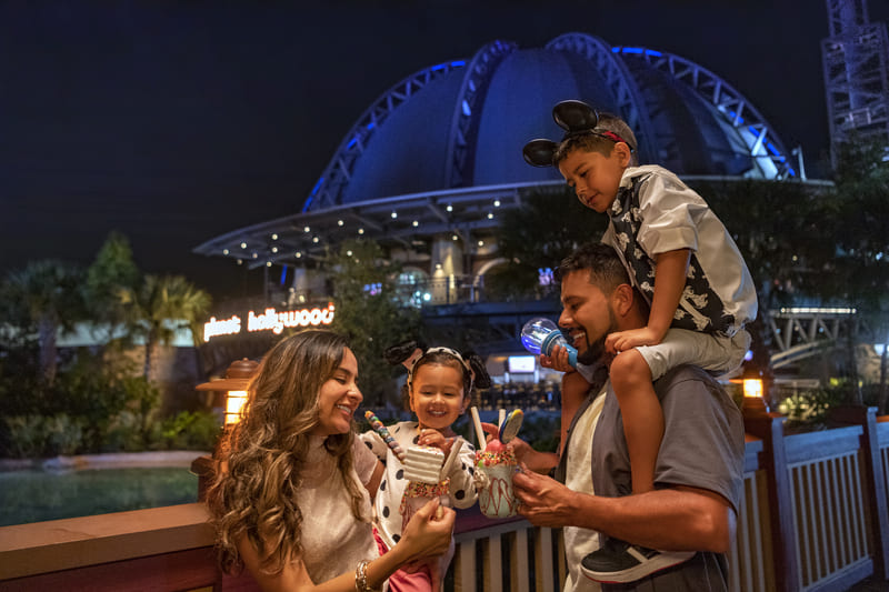Familia disfrutando postres en Disney Springs de noche