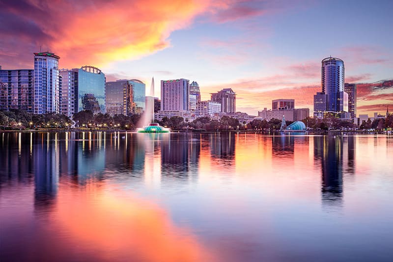 Orlando skyline reflecting on Lake Eola at sunset with vibrant sky colors