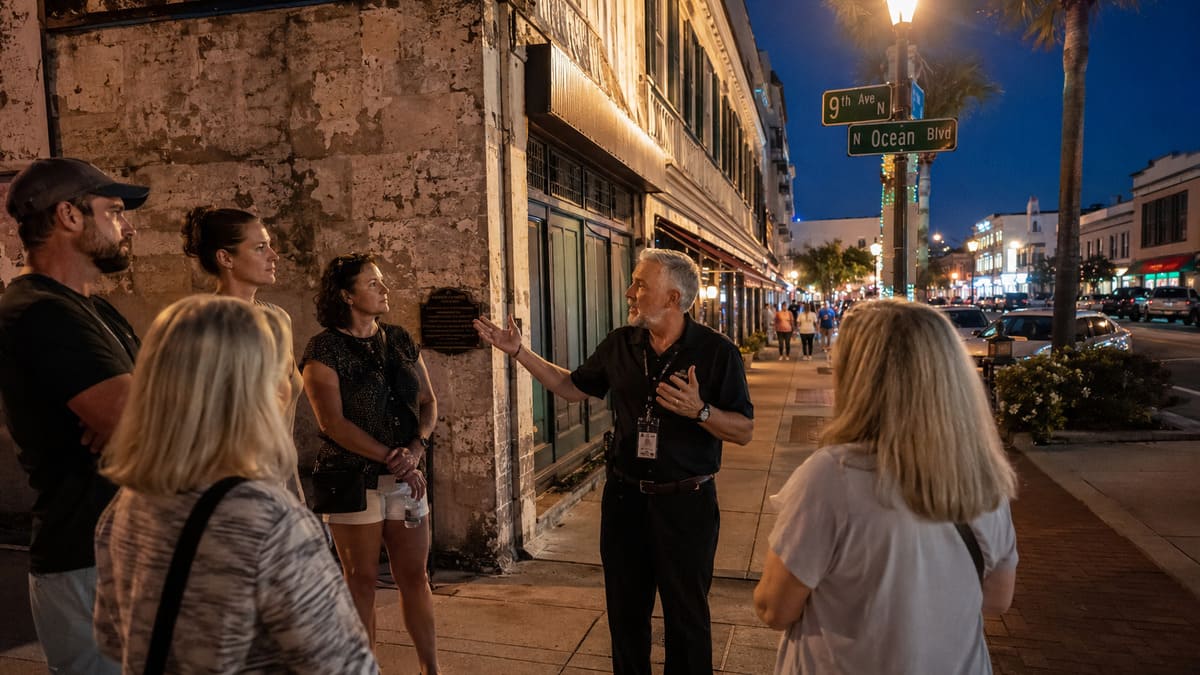 Small group listening to a guide during a ghost tour in downtown Myrtle Beach at night.