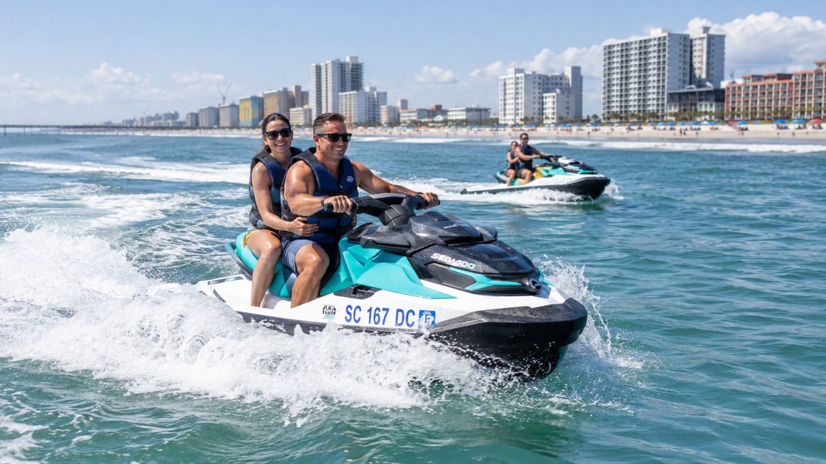 Couple riding a jet ski along the Myrtle Beach coastline on a sunny day.